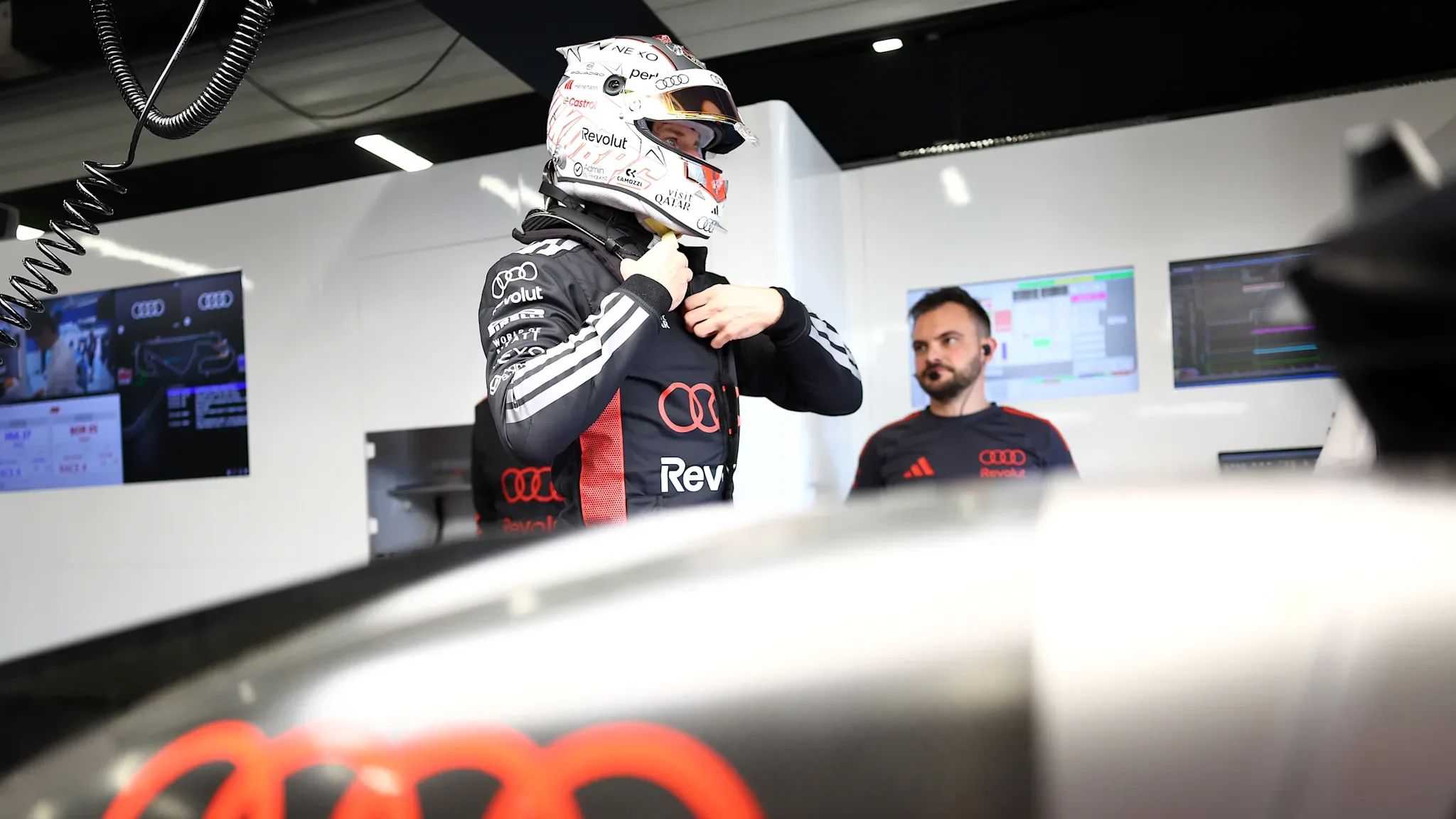 An Audi Formula 1 driver prepares in the garage during the team's 2026 works debut season