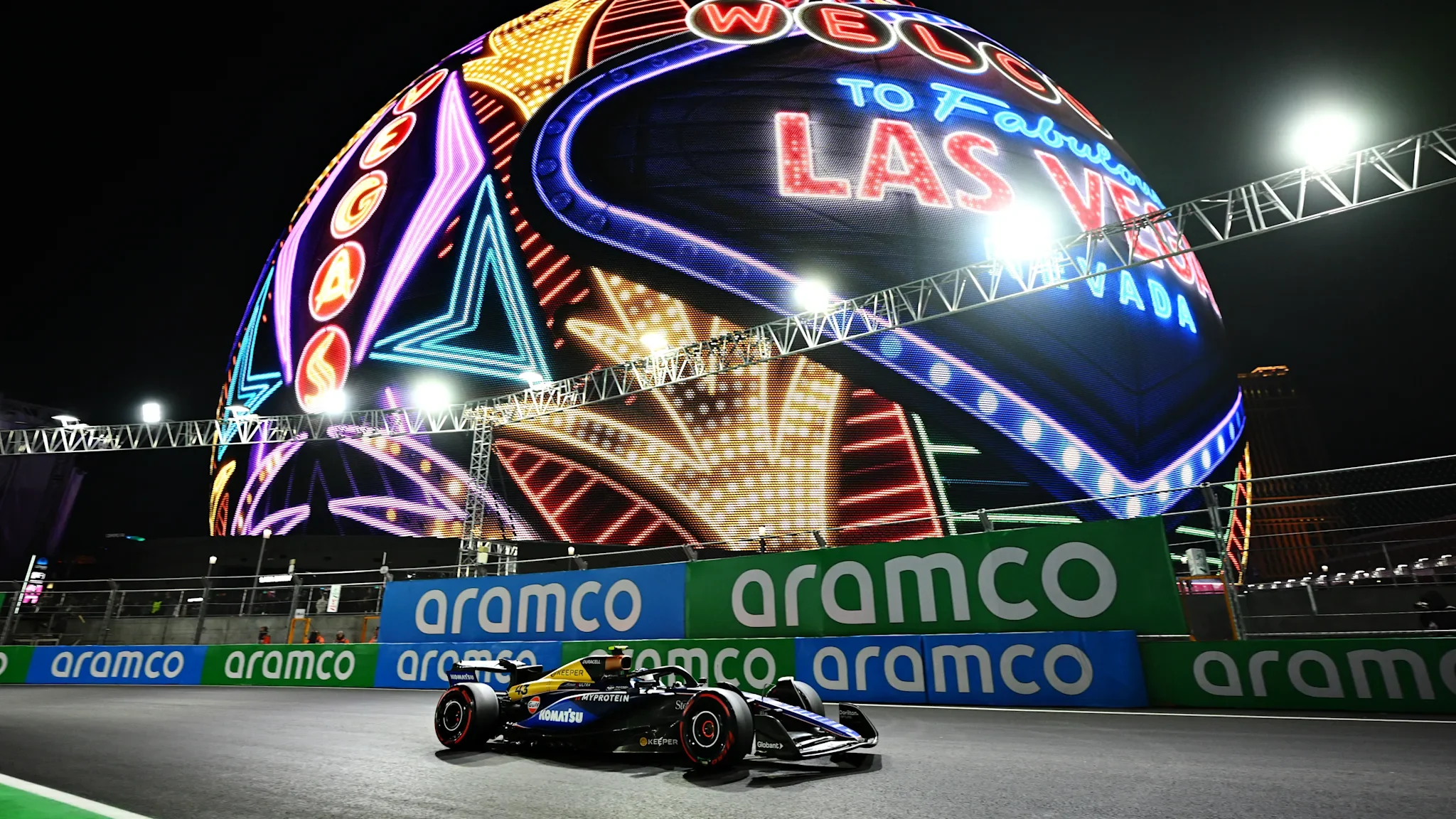 Formula 1 car racing beside the illuminated Sphere in Las Vegas