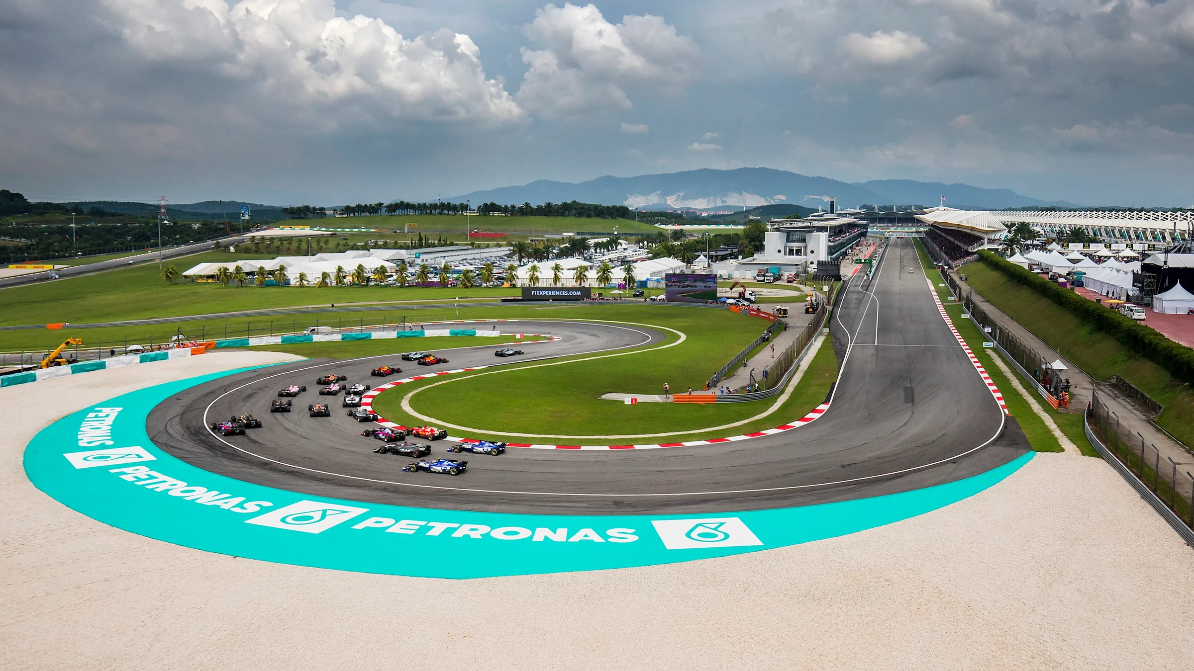 Formula 1 cars racing through a corner at Sepang International Circuit in 2017